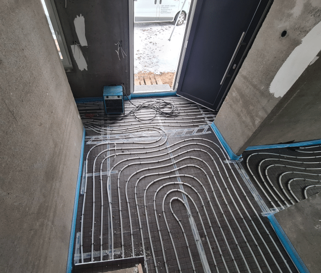 Fußbodenheizung und Pivot Tür im Neubau, gut geplante Installation von Fußbodenheizung für Einbau von Pivot-
Tür